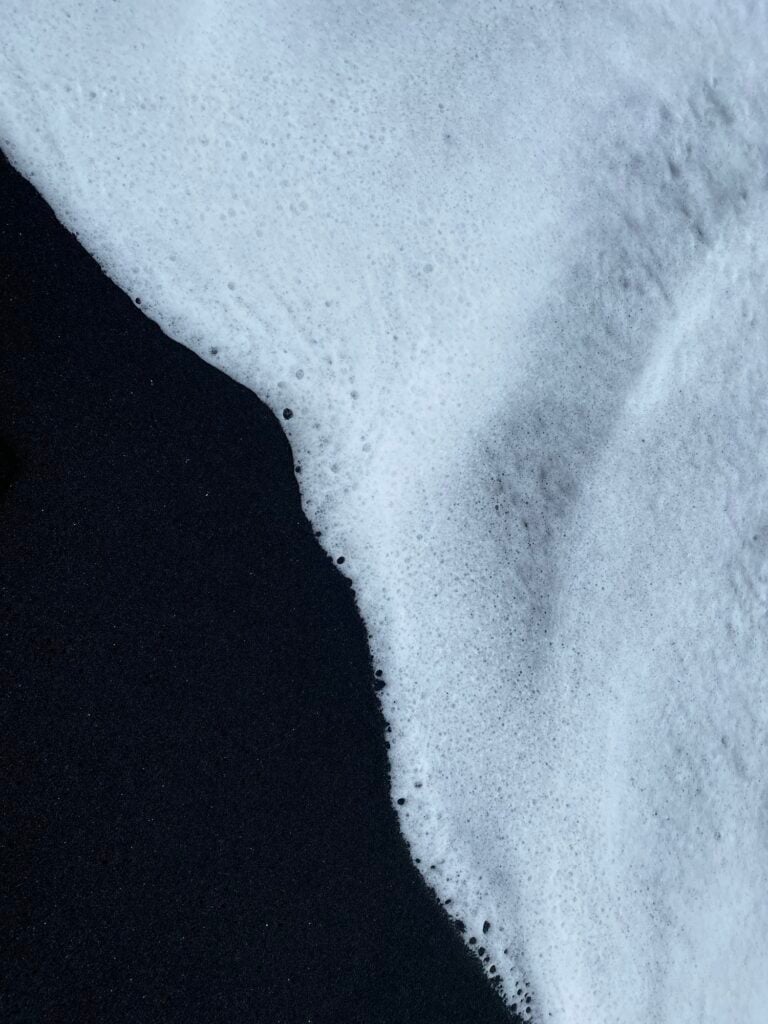 White surf washing over the black sand at Reynisfjara