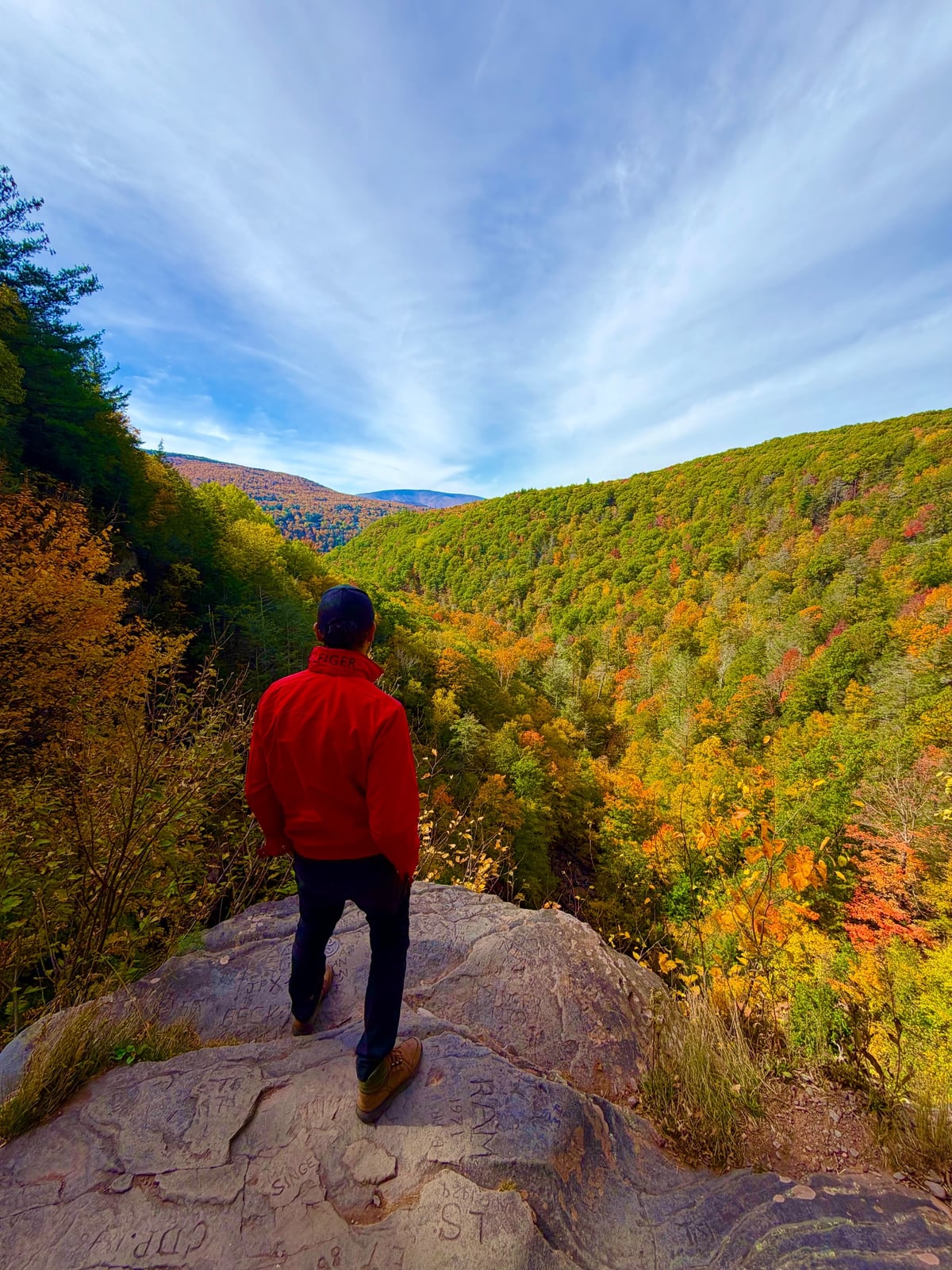 Standing on a rock ledge above Kaaterskill Clove with fall colors