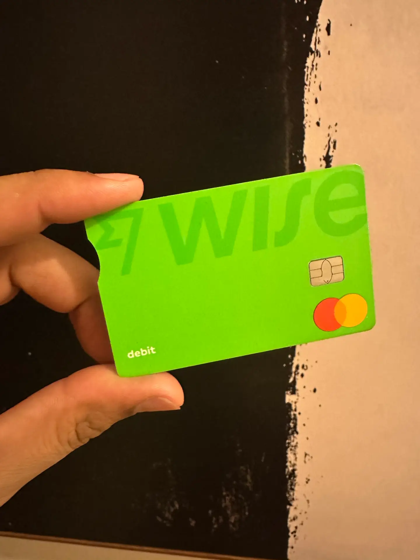 Alex holding a green Wise debit card